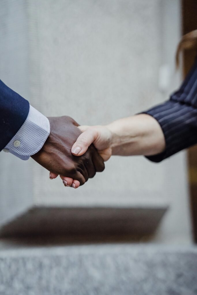 Close-up photo of diverse hands shaking, symbolizing partnership and cooperation.