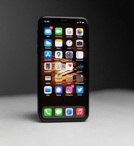 Close-up of a smartphone with an array of app icons against dark background.